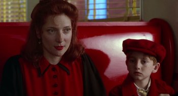 Movie still from “Dick Tracy” (1990), directed by Warren Beatty – A woman and a boy sitting on a red bench; Medium shot, Over the shoulder angle