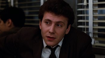 Movie still from “Diner” (1982), directed by Barry Levinson – A man in a suit and tie sitting in a room; Close Up shot, Low angle