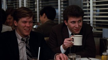 Movie still from “Diner” (1982), directed by Barry Levinson – Two young men sitting at a table drinking coffee; Medium shot, Over the shoulder angle