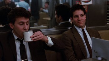 Movie still from “Diner” (1982), directed by Barry Levinson – Two men in suits and ties sitting on a train; Medium shot, Over the shoulder angle