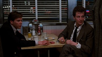 Movie still from “Diner” (1982), directed by Barry Levinson – Two men sitting at a table in a restaurant; Medium shot, Over the shoulder angle