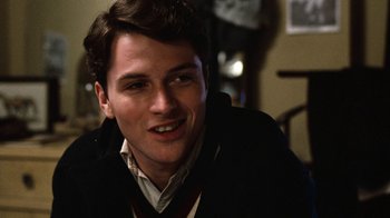 Movie still from “Diner” (1982), directed by Barry Levinson – A young man in a black jacket smiling for the camera; Close Up shot, Over the shoulder angle