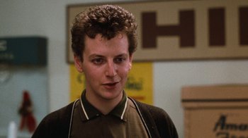 Movie still from “Diner” (1982), directed by Barry Levinson – A young man with curly hair is looking at the camera; Close Up shot, Low angle