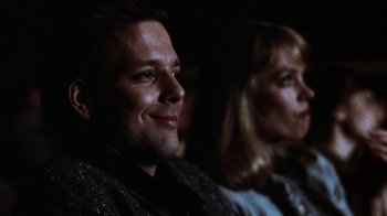 Movie still from “Diner” (1982), directed by Barry Levinson – A man and a woman sitting next to each other in a dark room; Close Up shot, Over the shoulder angle