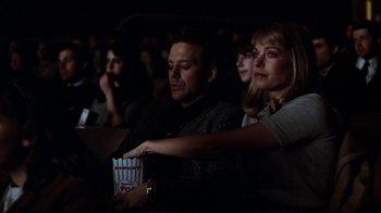 Movie still from “Diner” (1982), directed by Barry Levinson – A group of people sitting in a dark room eating popcorn; Medium shot, Low angle