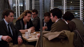 Movie still from “Diner” (1982), directed by Barry Levinson – A group of people sitting around a table; Medium shot, Over the shoulder angle