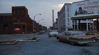 Movie still from “Diner” (1982), directed by Barry Levinson – An empty street with cars parked on the side of the road; Extreme Wide shot, High angle