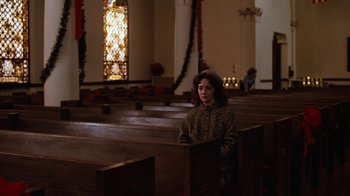 Movie still from “Diner” (1982), directed by Barry Levinson – A woman sitting in a pew in front of a stained glass window in a church; Wide shot, High angle