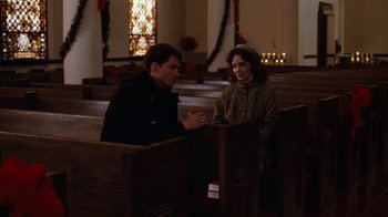 Movie still from “Diner” (1982), directed by Barry Levinson – A man and a woman sitting in a pew in a church; Medium shot, High angle