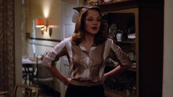 Movie still from “Diner” (1982), directed by Barry Levinson – A woman standing in front of a shelf in a room; Medium shot, Low angle