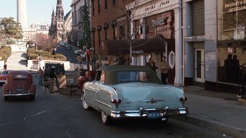 Movie still from “Diner” (1982), directed by Barry Levinson – An old car parked on the side of the street; Wide shot, High angle