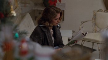 Movie still from “Diner” (1982), directed by Barry Levinson – A woman sitting in a chair reading a newspaper; Close Up shot, Over the shoulder angle