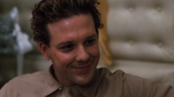 Movie still from “Diner” (1982), directed by Barry Levinson – A person wearing a brown shirt smiling; Close Up shot, Low angle