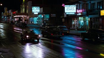 Movie still from “Diner” (1982), directed by Barry Levinson – A city street at night lit up by street lights; Extreme Wide shot, High angle