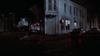 Movie still from “Diner” (1982), directed by Barry Levinson – A street corner at night with cars parked in front of it; Extreme Wide shot, High angle