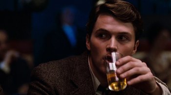 Movie still from “Diner” (1982), directed by Barry Levinson – A person holding a glass of beer; Close Up shot, Over the shoulder angle