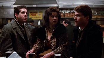 Movie still from “Diner” (1982), directed by Barry Levinson – A group of people that are sitting around a table; Medium shot, Over the shoulder angle