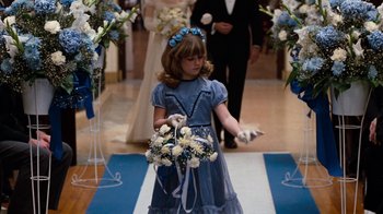 Movie still from “Diner” (1982), directed by Barry Levinson – A little girl in a blue dress holding a bouquet of flowers; Medium shot, Over the shoulder angle