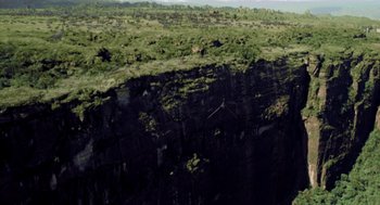 Movie still from “Dinosaur” (2000), directed by Eric Leighton – A view of a cliff from a plane window; Extreme Wide shot, Overhead angle