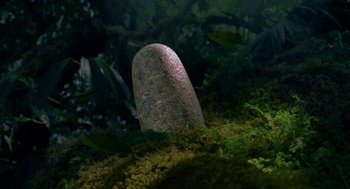 Movie still from “Dinosaur” (2000), directed by Eric Leighton – A stone in the middle of a forest; Wide shot, High angle