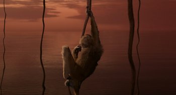 Movie still from “Dinosaur” (2000), directed by Eric Leighton – A monkey hanging from a rope over a body of water; Wide shot, High angle