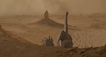 Movie still from “Dinosaur” (2000), directed by Eric Leighton – An animal with long horns is in the middle of the desert; Extreme Wide shot, High angle
