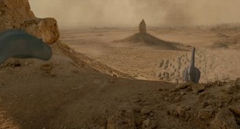 Movie still from “Dinosaur” (2000), directed by Eric Leighton – An image of a desert scene with a person standing in the middle of the desert; Extreme Wide shot, High angle