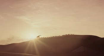 Movie still from “Dinosaur” (2000), directed by Eric Leighton – A person riding skis on top of a snow covered slope; Extreme Wide shot, Low angle