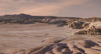 Movie still from “Dinosaur” (2000), directed by Eric Leighton – A sandy beach with a mountain in the background; Extreme Wide shot, High angle