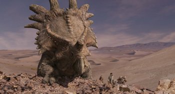 Movie still from “Dinosaur” (2000), directed by Eric Leighton – An image of an animal that is sitting in the dirt; Extreme Wide shot, Low angle