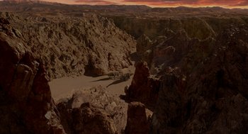 Movie still from “Dinosaur” (2000), directed by Eric Leighton – A view of a desert landscape from above at sunset; Extreme Wide shot, High angle