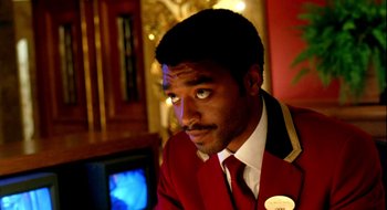 Movie still from “Dirty Pretty Things” (2002), directed by Stephen Frears – A man wearing a red jacket and a white shirt; Close Up shot, Over the shoulder angle