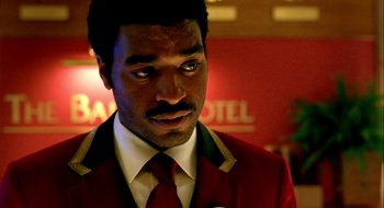 Movie still from “Dirty Pretty Things” (2002), directed by Stephen Frears – A person wearing a suit and tie; Close Up shot, Over the shoulder angle