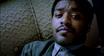 Movie still from “Dirty Pretty Things” (2002), directed by Stephen Frears – A person wearing a suit and tie; Close Up shot, Overhead angle