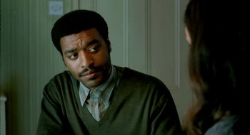 Movie still from “Dirty Pretty Things” (2002), directed by Stephen Frears – A man sitting in front of a mirror looking at a woman; Close Up shot, Over the shoulder angle