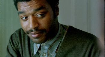 Movie still from “Dirty Pretty Things” (2002), directed by Stephen Frears – A person wearing a shirt and tie; Close Up shot, Over the shoulder angle