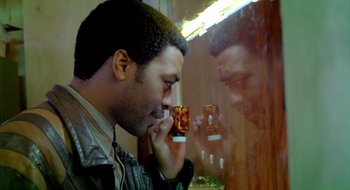 Movie still from “Dirty Pretty Things” (2002), directed by Stephen Frears – A man holding a cell phone up to his face; Close Up shot, Low angle