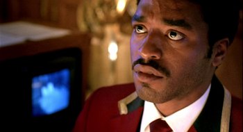 Movie still from “Dirty Pretty Things” (2002), directed by Stephen Frears – A person wearing a suit and tie; Close Up shot, Low angle