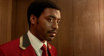 Movie still from “Dirty Pretty Things” (2002), directed by Stephen Frears – A person wearing a suit and tie; Close Up shot, Over the shoulder angle