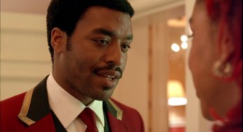 Movie still from “Dirty Pretty Things” (2002), directed by Stephen Frears – A person wearing a suit and tie; Close Up shot, Over the shoulder angle