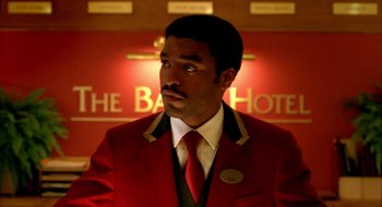 Movie still from “Dirty Pretty Things” (2002), directed by Stephen Frears – A man in a red jacket and a red tie; Medium shot, Low angle