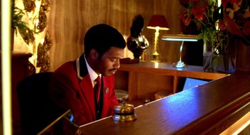 Movie still from “Dirty Pretty Things” (2002), directed by Stephen Frears – A man sitting at a table in a room; Medium shot, High angle