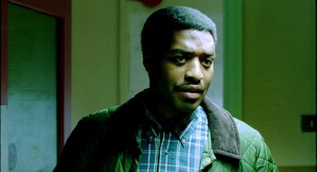Movie still from “Dirty Pretty Things” (2002), directed by Stephen Frears – A person wearing a green jacket; Close Up shot, Over the shoulder angle