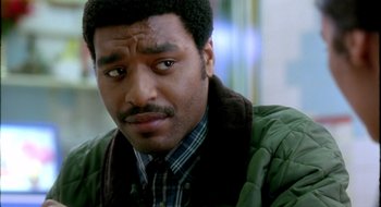 Movie still from “Dirty Pretty Things” (2002), directed by Stephen Frears – A person wearing a green jacket; Close Up shot, Over the shoulder angle