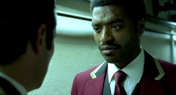 Movie still from “Dirty Pretty Things” (2002), directed by Stephen Frears – A man wearing a suit and tie looking at himself in the mirror; Close Up shot, Over the shoulder angle