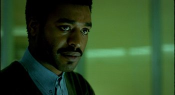 Movie still from “Dirty Pretty Things” (2002), directed by Stephen Frears – A person wearing a shirt and tie; Close Up shot, Low angle