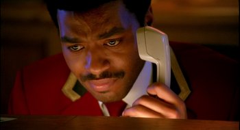 Movie still from “Dirty Pretty Things” (2002), directed by Stephen Frears – A man holding a phone up to his ear; Close Up shot, Low angle