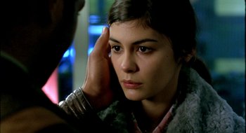 Movie still from “Dirty Pretty Things” (2002), directed by Stephen Frears – A woman with a hand on her head looking at the camera; Close Up shot, Over the shoulder angle