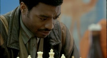 Movie still from “Dirty Pretty Things” (2002), directed by Stephen Frears – A person playing a game of chess; Close Up shot, Over the shoulder angle