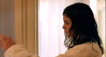 A young woman with wet hair looking into a mirror